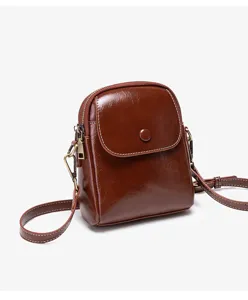 Detailed view of fashionable brown leather small square shoulder bag with chic button flap design.