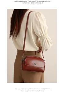 Close-up detail of retro oil-wax leather shoulder crossbody bag in dark red brown with sunburst buckle.