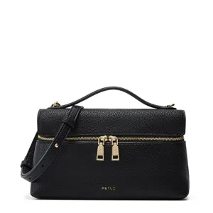 Black textured leather vanity bag detail showing gold zippers and embossed brand logo.