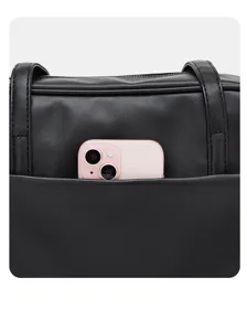 Detailed view of black PU leather shoulder bag featuring front pocket holding smartphone securely.