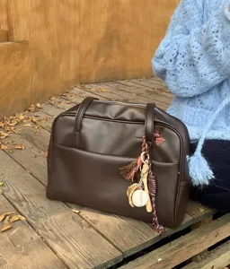 Detailed view of the retro brown Boston bag with charms, showcasing premium texture and design.