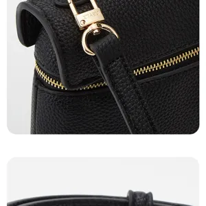Black textured leather shoulder bag detail, elegant gold hardware zipper close up view.