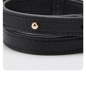 Black leather bag strap detail with gold tone stud, vintage luxury style fashion handbag accessory.