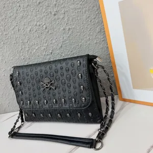 Black punk style skull embossed chain envelope shoulder bag with metal studs.