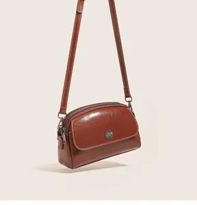 Vintage oil wax leather crossbody bag detail, retro style brown multi-compartment womens purse.