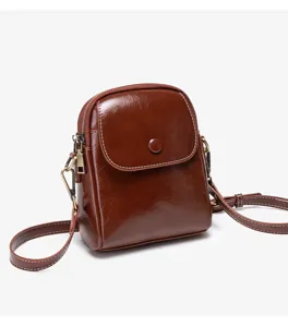Detail view of the retro brown leather small crossbody bag with metal hardware and zipper closure.