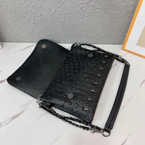 Punk style black skull embossed chain envelope bag detail view, trendy shoulder cross-body bag.