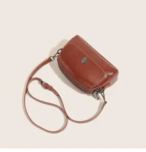 Vintage oil-wax leather cross-body bag detail, brown women's shoulder bag with metal buckle.