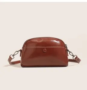 Detailed closeup view of the vintage oil wax leather dome shell crossbody bag in rich brown.