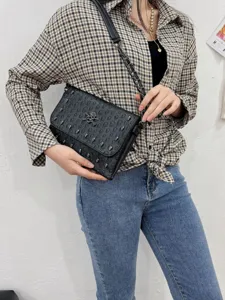 Punk style black skull embossed leather crossbody bag with chain strap for women fashion trend.