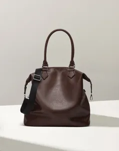 Close-up details of the brown shoulder bag, featuring textured faux leather and strap.