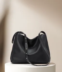 Detail view of black leather hobo shoulder bag featuring metal eyelets and large capacity.