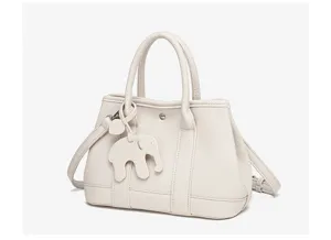 White leather shoulder handbag with cute elephant charm, versatile stylish tote bag.