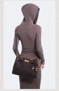 Retro suede shoulder bag detail showing premium texture, metal lock and cute puppy charm.
