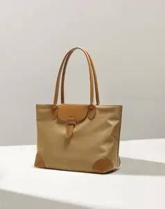 Detailed view of the casual nylon tote bag, featuring brown leather handles and flap.