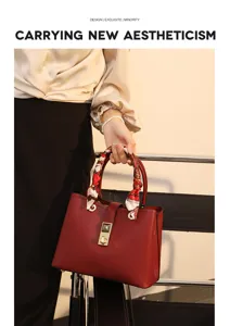 Elegant wine red leather tote bag with stylish scarf handle and metal lock detail.