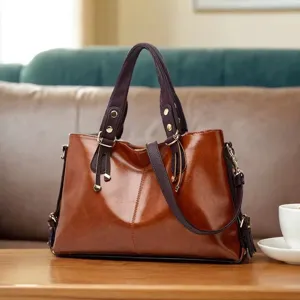 Brown leather handbag detail view, premium cowhide shoulder bag with fine stitching.