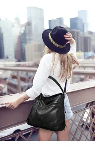 Detailed view of stylish black hobo shoulder bag in urban setting, perfect for daily fashion.