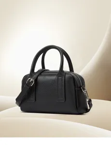 Close-up of black pebbled leather handbag with silver hardware and neat stitching details.