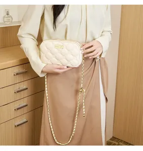 Beige quilted small square bag with gold chain strap, elegant shoulder bag detail showcase.