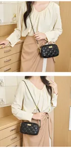 Detailed view of black quilted crossbody bag with luxury chain strap, elegant daily fashion accessory.