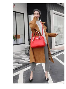 Red leather texture fashion handbag with lock closure, stylish crossbody tote bag detail.