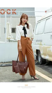 Close-up view of the elegant brown leather tote bag with a matching sub-bag accessory, outdoor scene.