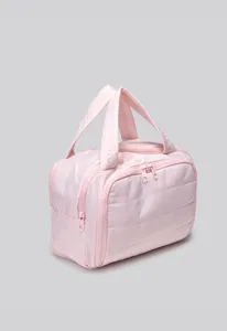 Close-up view of the pink quilted toiletry bag highlighting fabric texture and zippers.