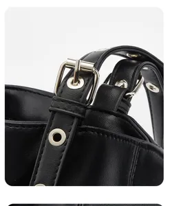 Close-up detail of black leather bag strap, featuring metal buckle and grommet accents.