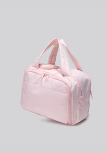 Detailed view of the stylish pink quilted travel cosmetic bag with double handles and zipper.