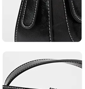 Detailed view of black leather handbag featuring contrast white stitching and premium handle.