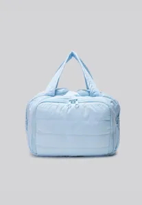 Closeup view of light blue quilted cosmetic bag, featuring soft fabric and smooth zipper.