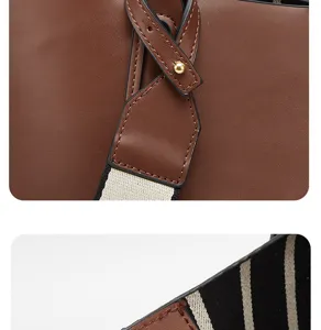 Detailed view of women brown tote bag with contrast striped strap and chic decorative buckle.