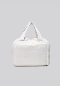 White quilted cosmetic bag detail view, lightweight travel pouch with double zippers and handle.