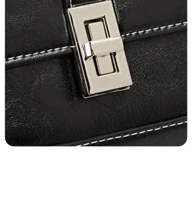 Close-up of black retro PU leather handbag with silver turn-lock and white contrast stitching.