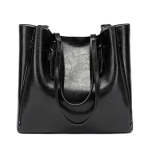 Detail view of large capacity black oil leather tote bag with dual handles and zippers.