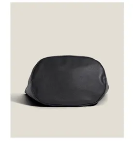Detailed view of the black textured leather bucket bag bottom, showcasing fine craftsmanship.