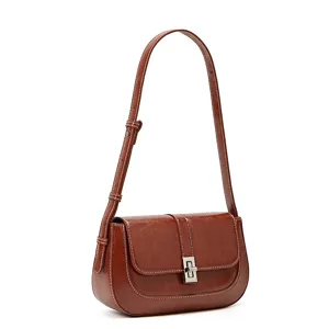 Vintage brown leather shoulder bag with chic metal twist lock and elegant white contrast stitching.