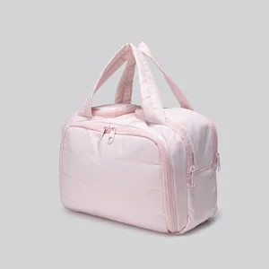 Light pink quilted travel cosmetic bag, waterproof portable toiletry handbag for women.