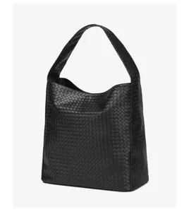 Close-up view of the black woven leather shoulder bag highlighting the fine texture detail.