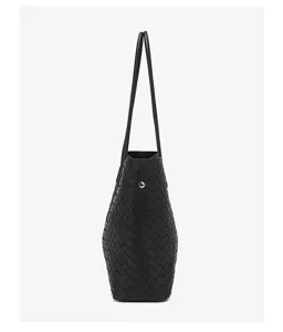 Black woven leather tote bag with shoulder straps and spacious design for daily use.