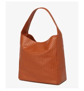 Detailed view of brown woven leather shoulder bag showing intricate texture and slouchy design.