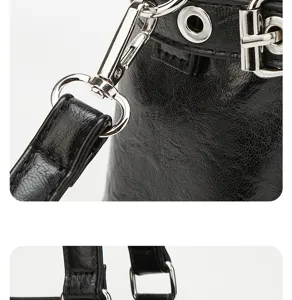 Detailed view of black faux leather handbag showing silver hardware, buckles and straps.