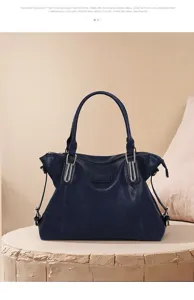 Dark blue leather tote bag detail showcasing smooth texture, sturdy handles and metal hardware.