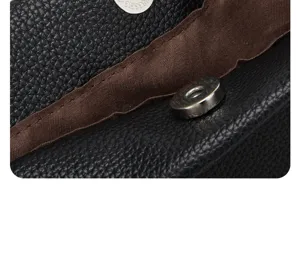 Black PU leather bag detail close up showing magnetic snap button and brown lining interior.