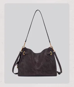 Detailed view of retro faux suede shoulder bag with metallic lock and strap decor in dark grey.