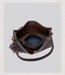 Retro suede shoulder bag detail showing interior compartment, zipper pouch, and charm.