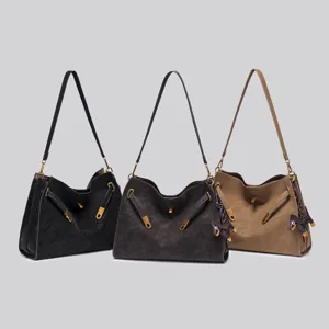 Detailed view of vintage suede shoulder bag with metal lock and strap decoration.