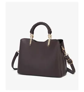 Dark brown leather handbag detail featuring a stylish braided top handle and gold hardware.