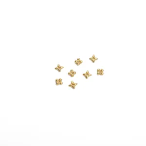 Gros plan de perles intercalaires dorées en forme d'étoile et de fleur pour bijoux